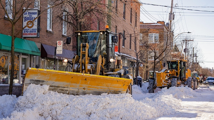 Des chasse-neige déneigent une rue de Montréal.