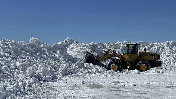 Une machine déplace de la neige.
