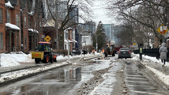 De la machinerie ramasse la neige sur la rue Wellington Ouest à Toronto, le 24 février 2025.