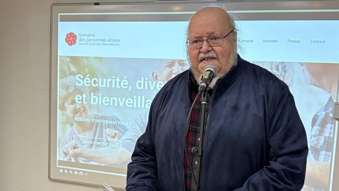 Denis Bélanger parle au micro à son public. 