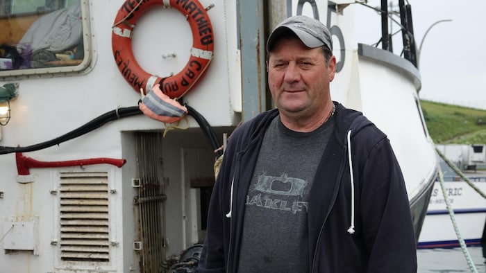 Denis Éloquin devant son bateau.