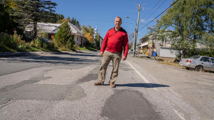 Un homme au milieu d'une rue dans un village.