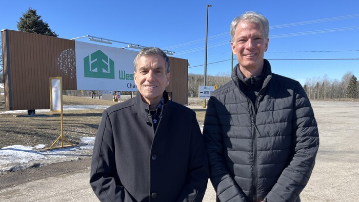Deux hommes devant les installations de West Fraser.