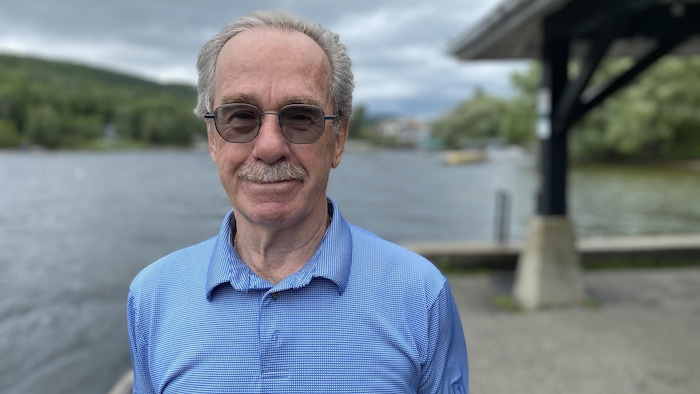 Denis Petitclerc sourit à la caméra, devant le lac Massawippi.