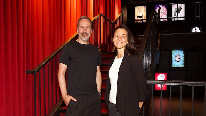 L'homme et la femme posent en souriant dans les escaliers de la salle de cinéma.