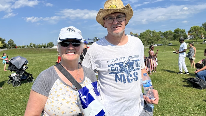 Two smiling people with their Quebec flag. gathering family national holiday rimouski gathering family national holiday rimouski new