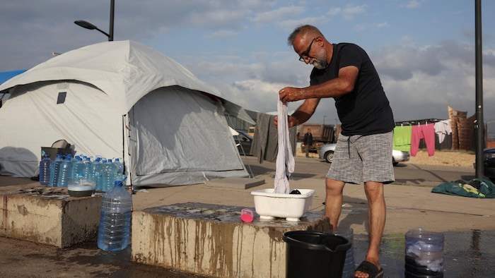 Un déplacé lave son linge dans un campement improvisé dans le centre-ville de Beyrouth, le 19 avril 2026.