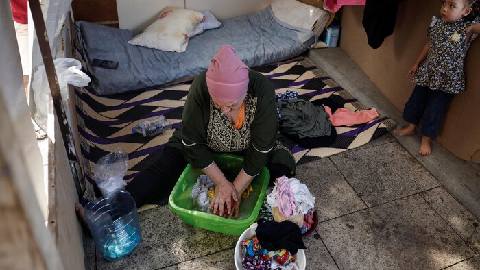 Une déplacée libanaise lave les vêtements de sa fille dans un refuge à Beyrouth.