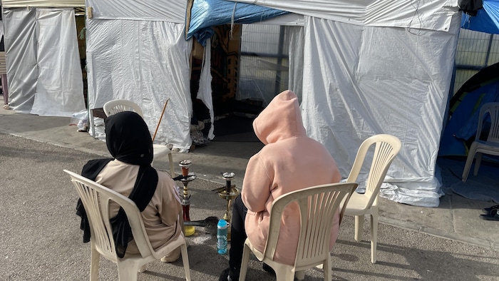 Deux déplacées fument de la chicha devant leur tente dans le centre-ville de Beyrouth.