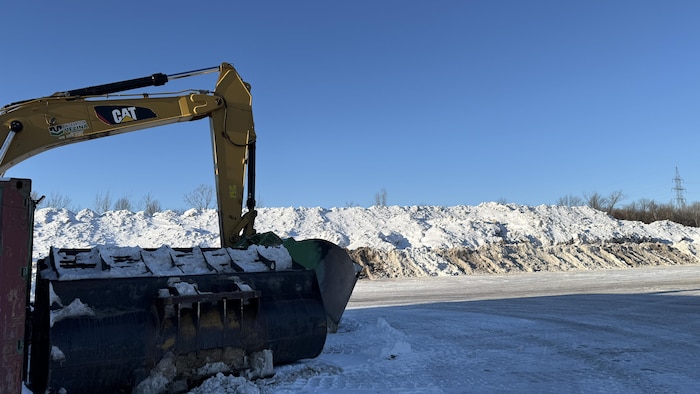 Une montagne de neige et une pelle mécanique.