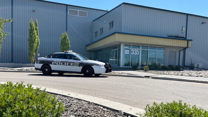 Une voiture de police se trouve devant le dépôt de recyclage.