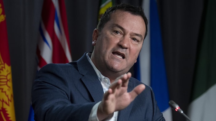 Alain Therrien debout dans la salle de presse du Parlement.