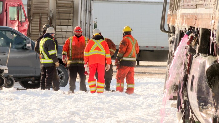 Des travailleurs près des wagons du train déraillé.