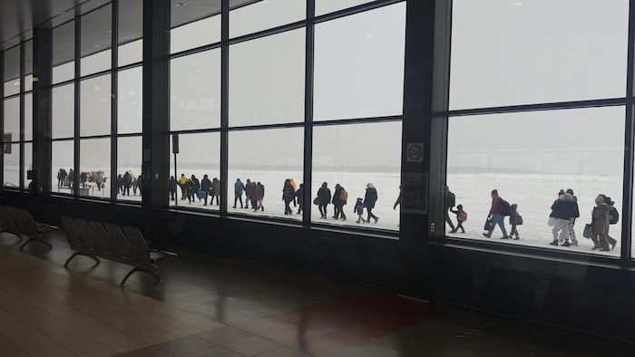 Une fil de passagers en direction de l'avion.
