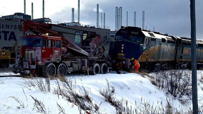 Un remorqueur s'affaire à remettre une locomotive sur ses rails.