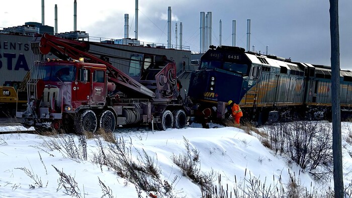 Des employés s'affairent près d'une locomotive qui a déraillé à Saint-Alexandre-de-Kamouraska