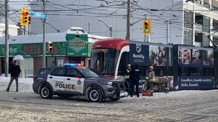 Un véhicule de police devant le tramway qui a déraillé sur la rue Queen à Toronto, le 26 janvier 2026.
