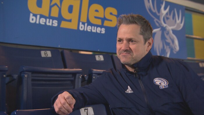 Derek Cormier assis dans les gradins d'un aréna.