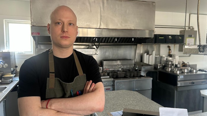 Derek Desjardins pose pour la photo dans la cuisine de la cantine.