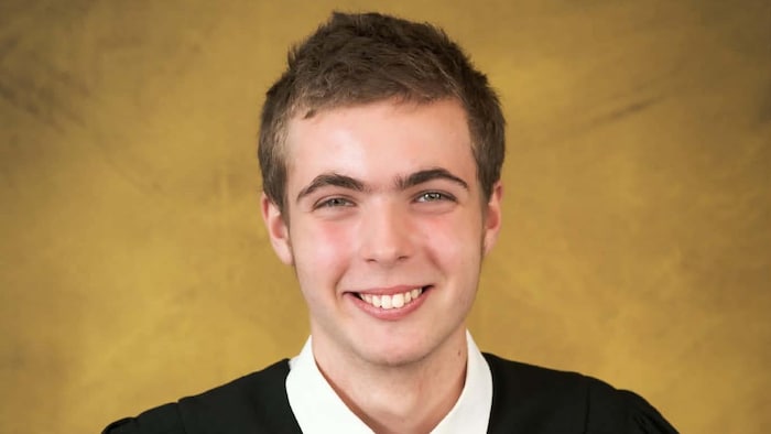 Derek Godin-Rioux sourit pour une photo de graduation.