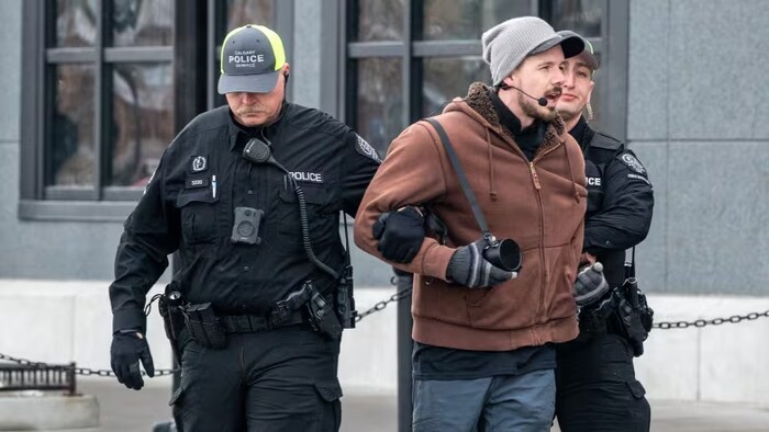 Un homme entre les mains de deux agents de police, à Calgary, en Alberta.