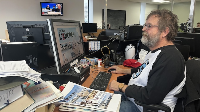 Un homme regarde son écran d'ordinateur.