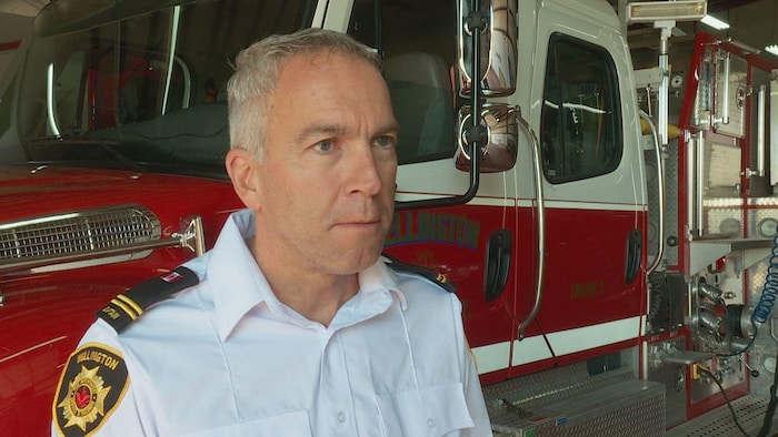 Desmond Arsenault en entrevue devant un camion de pompiers.