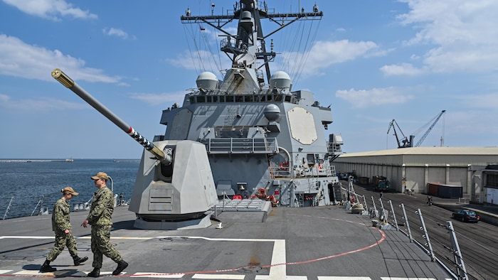 Des soldats marchent sur le pont d'un destroyer.