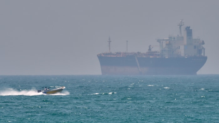Un bateau passe devant un pétrolier ancré dans le détroit d'Ormuz.
