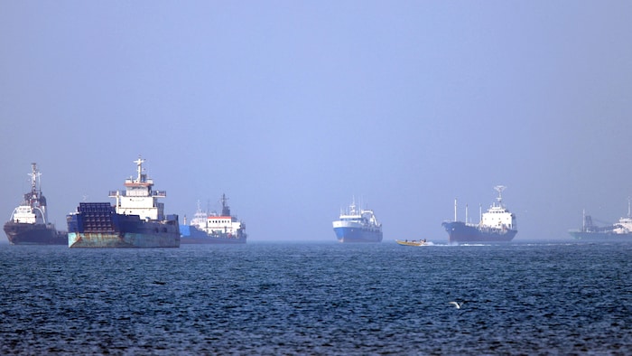 Des navires ancrés dans la mer attendent.
