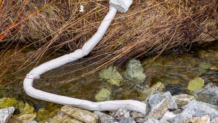Un petit barrage portable installé sur la surface d'un ruisseau.