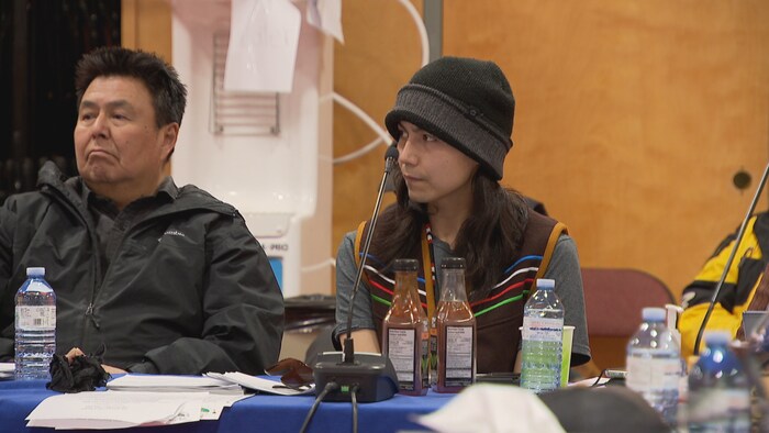 Devon Felker est assis à une table lors de l'Assemblée nationale dénée.