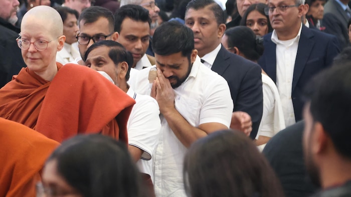 Des personnes se recueillent.