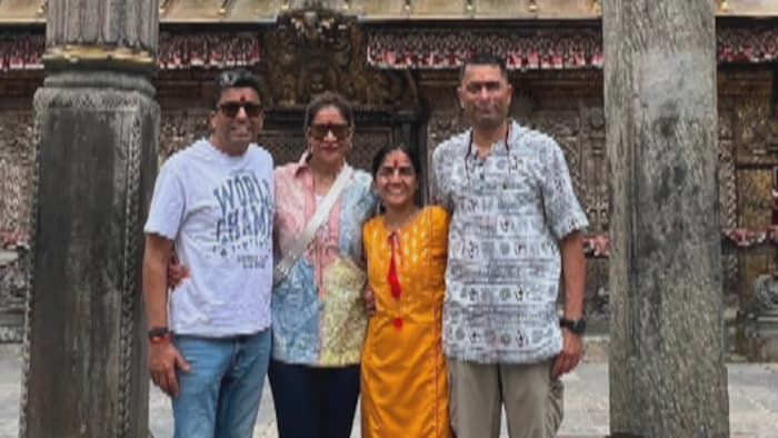 Dhaval Shah et Megha Shah posant avec deux personnes devant un temple.