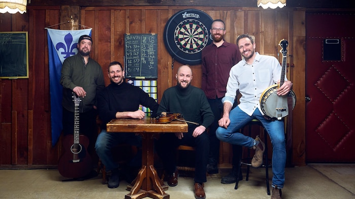 Portrait de cinq hommes avec leur instrument de musique.