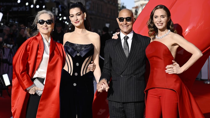 Trois femmes et un homme sourient. 