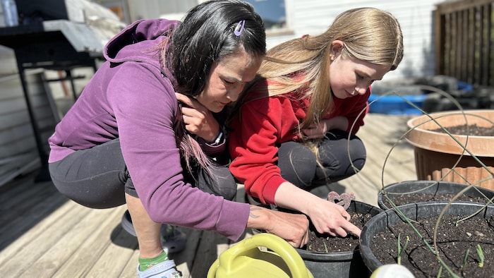 Diana Boston, left, plans to water her vegetable garden by hand through the coming months, but worries the restrictions may be too hasty. 