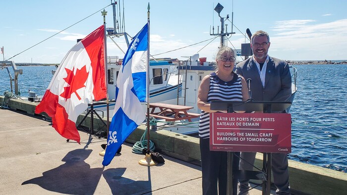 Diane Lebouthillier et Antonin Valiquette derrière un lutrin sur un quai.