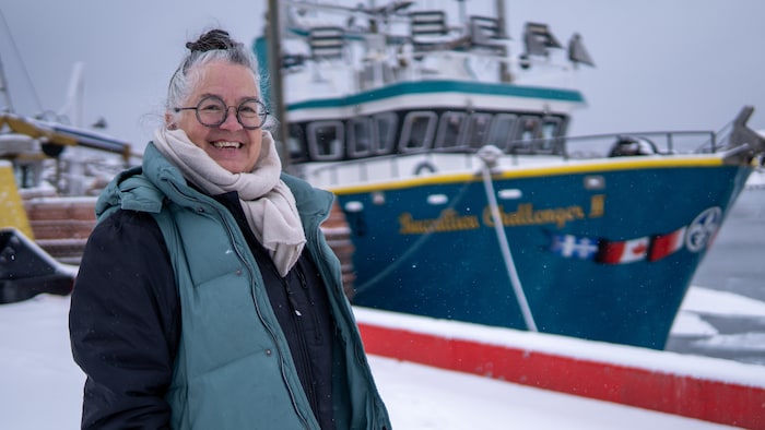 Diane Lebouthillier, photographiée devant un bateau de pêche.