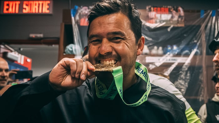 L'entraîneur-chef de l’Atlético Ottawa, Diego Mejía, mord dans une médaille.