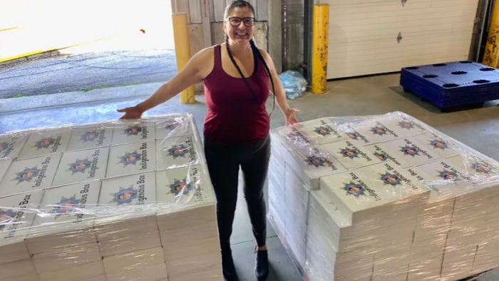 Una mujer muestra productos en venta.