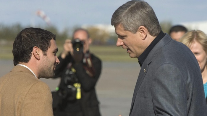 Dimitri Soudas parle avec Stephen Harper.