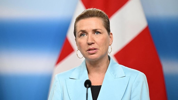 Mette Frederiksen prononce un discours devant un drapeau du Danemark.