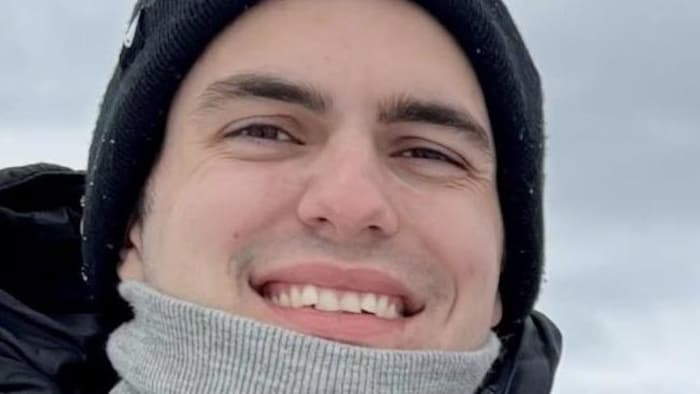 Zack Villemure, en habit d'hiver, sourit à la caméra.