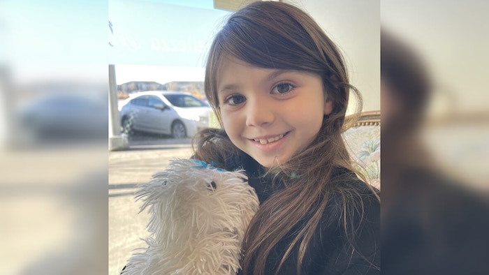 Zuri Sawatzky sourit avec une peluche dans les mains.
