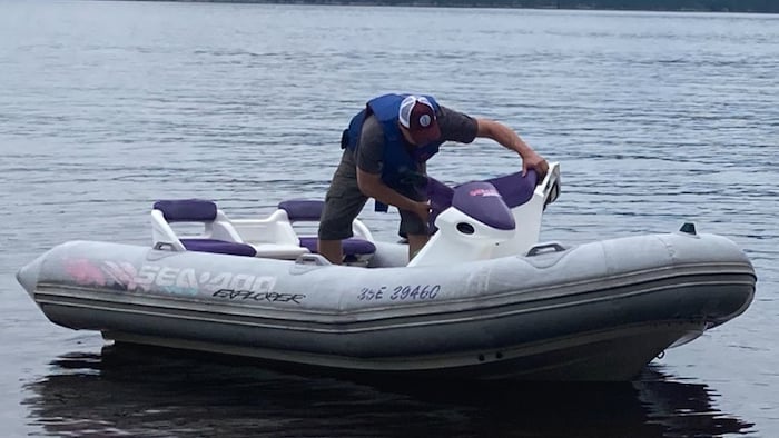 Un homme est sur un bateau pneumatique.
