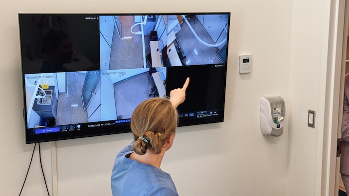Une infirmière pointe différents points de vue de caméras de surveillance.