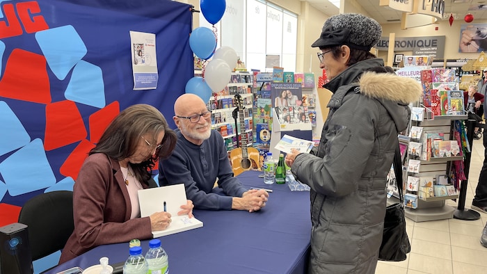 Des artistes signent des livres.