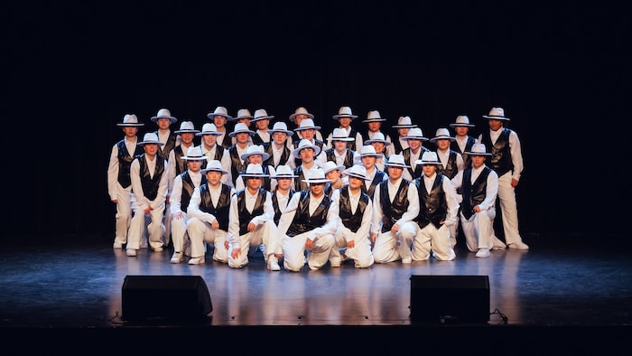 Une troupe de danseurs sur scène. 