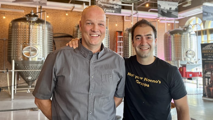 Deux hommes sourient.
